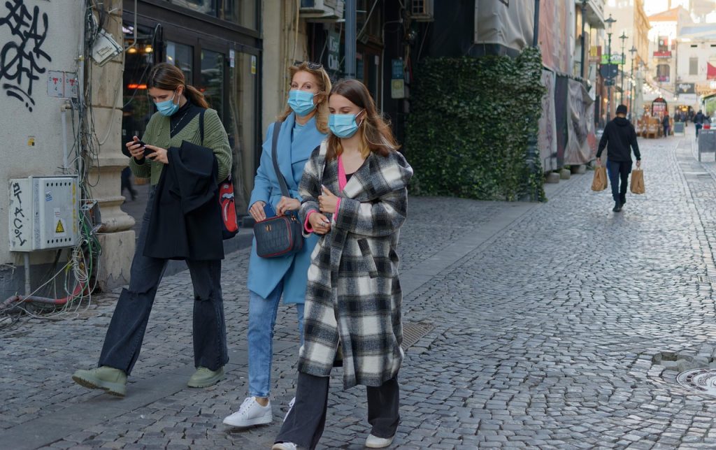personnes dans la rue portant un masque